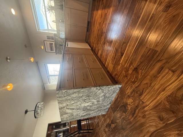 Natural wood cabinets with granite waterfall countertop