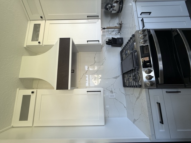 Modern kitchen with white cabinetry and dark countertops